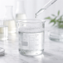 Chemical experiment featuring a clear glass beaker with clear surfactant liquid exploring if all sulfates are bad