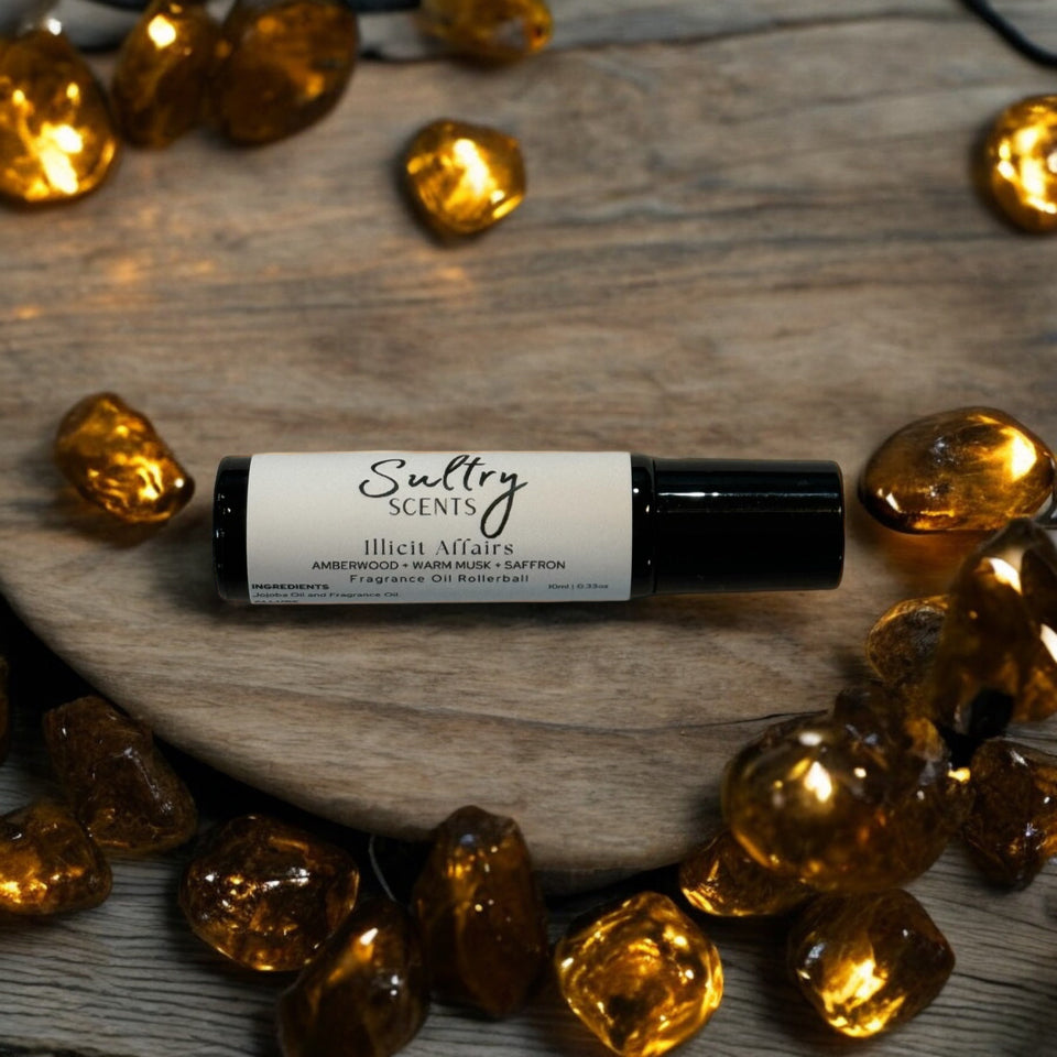 Roll-on perfume oil in a stylish glass bottle surrounded by decorative amber stones