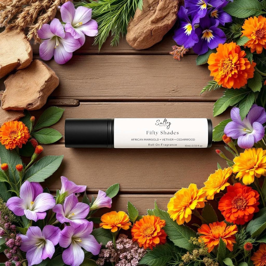 Sultry Scents roll on fragrance oil displayed on wooden board with colorful flowers Bal dAfrique inspired Roll On Perfume