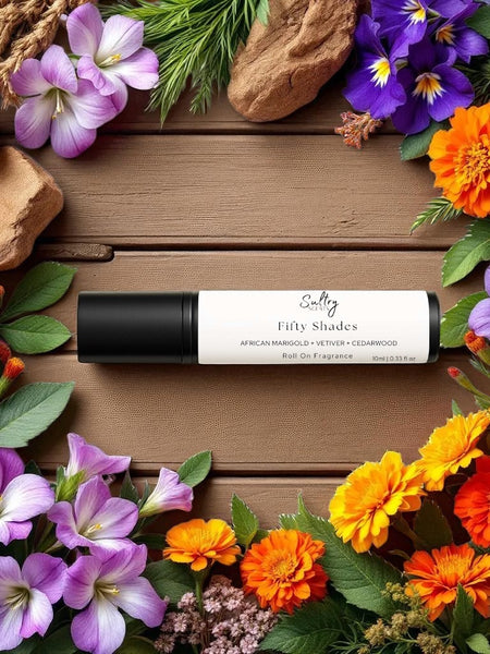 Sultry Scents roll on fragrance oil displayed on wooden board with colorful flowers Bal dAfrique inspired Roll On Perfume