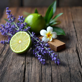 Fresh lime, lavender sprigs, plumeria flower, and wood on rustic table for Bleu de Chanel dupe roll on perfume