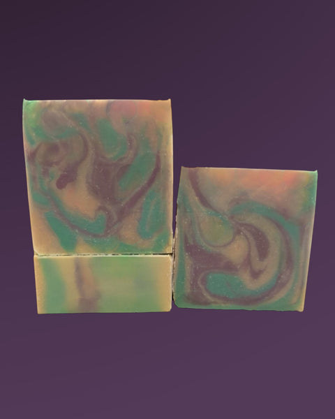 Sultry Scents butterfly pea flower soap bars with green and purple swirled design on a purple background
