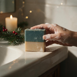 Christmas Tree Scented Soap in Hand with Soft Bubbles by a Candle and Holiday Greens
