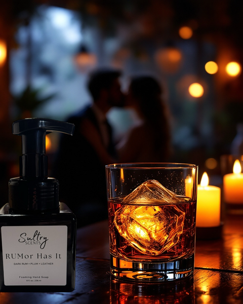 Sultry Scents Dark Rum inspired luxury hand soap bottle next to glass of rum with ice and candles