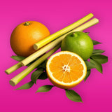Fresh orange, lime, sugarcane sticks, and green leaves on pink background for Essential Oil Inhaler