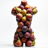 Father Figure body spray dupe by Sultry Scents displayed on a sculpted torso covered with fresh figs