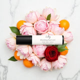 Sultry Scents Good Girl Blush inspired roll on perfume with floral elements on a marble background