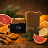 Sultry Scents Handcrafted turmeric soap made with tallow displayed with citrus fruits and turmeric root