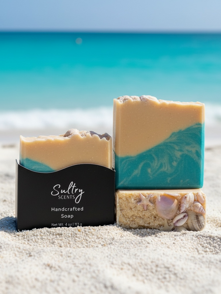 Luxury beach soap bar by Sultry Scents with ocean-inspired colors and natural shell accents located on a sand beach with turquoise water.