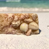Luxury beach soap bar decorated with soap seashells and starfish on sandy shoreline