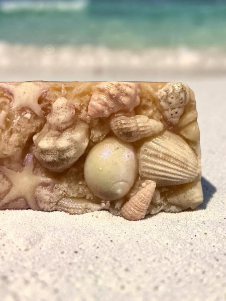 Luxury beach soap bar decorated with soap seashells and starfish on sandy shoreline