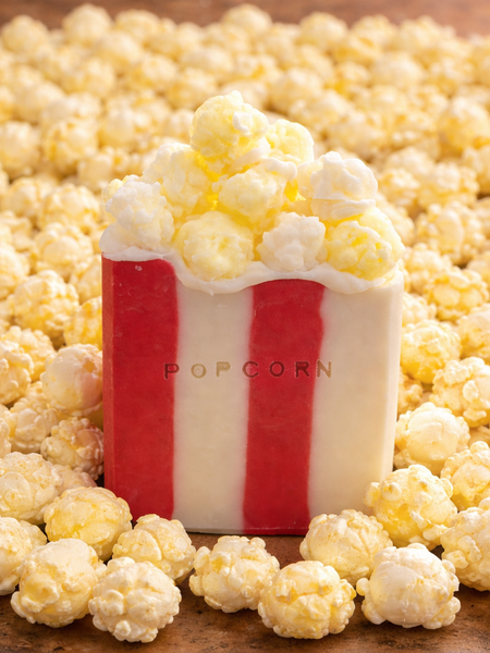 Novelty Popcorn Soap Bar with realistic popcorn topping, surrounded by popcorn kernels for a playful touch
