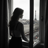 Silhouette of a woman looking out window at Paris cityscape with Eiffel Tower in background Phlur Missing Person inspired foaming hand soap