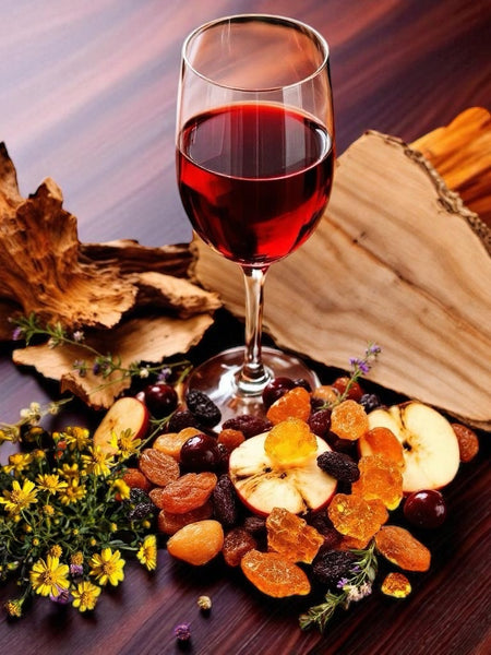 Glass of red wine with dried fruits and flowers artfully arranged for Sultry Scents red wine perfume soap