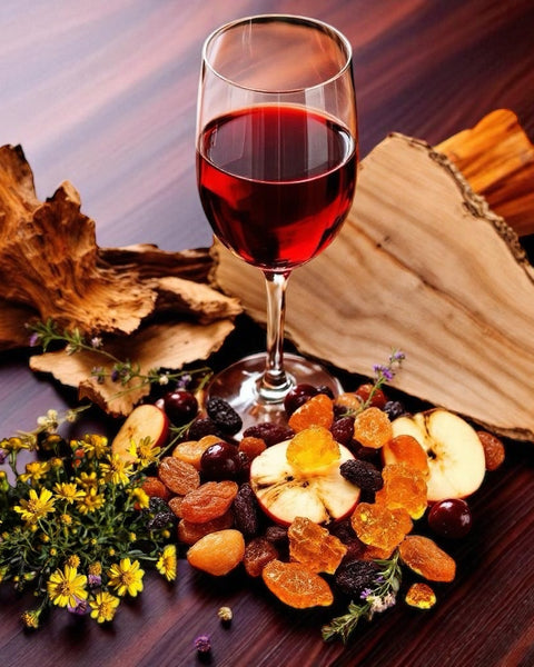 Glass of red wine with dried fruits and flowers artfully arranged for Sultry Scents red wine perfume soap