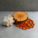 Roll on Perfume inspired by Alien with amber stones, Cashmere Wood, and Arabian Jasmine on gray surface