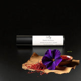 Sultry Scents Black Saffron dupe roll on perfume with dark violet flower and saffron threads on black background