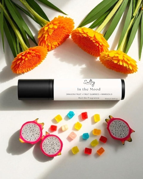 Sultry Scents In the Mood roll on fragrance with colorful gummies, marigold flowers, and dragon fruit slices Phlur mood ring dupe roll on fragrance
