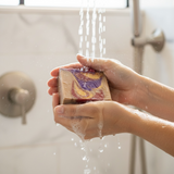 Luxury soap inspired by Baccarat Rouge 540, featuring a swirl design and water running over it in the shower