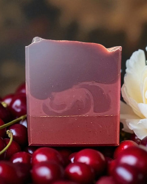Black Cherry Silk soap bar by Sultry Scents with layered cherry red design surrounded by fresh cherries and white flower