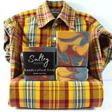 Fall Flannel Soap Bar displayed next to a cozy plaid shirt, emphasizing its handcrafted elegance