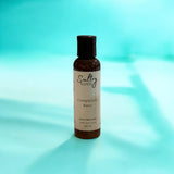 Sultry Scents goat milk body cream bottle labeled Completely Bare on blue background
