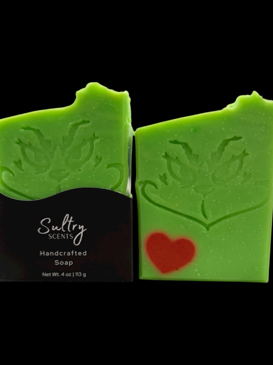 Holiday Grump soap bar by Sultry Scents, vibrant green with Grinch face and red heart