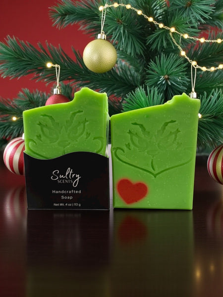 Holiday Grump soap bar from Sultry Scents, featuring festive green with a Grinch face and red heart for holiday cheer