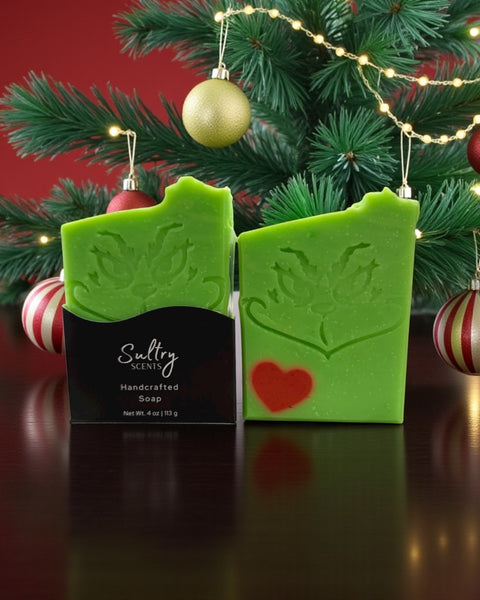 Holiday Grump soap bar from Sultry Scents, featuring festive green with a Grinch face and red heart for holiday cheer