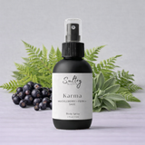 Sultry Scents Huckleberry body spray in a sleek bottle with fern and sage background