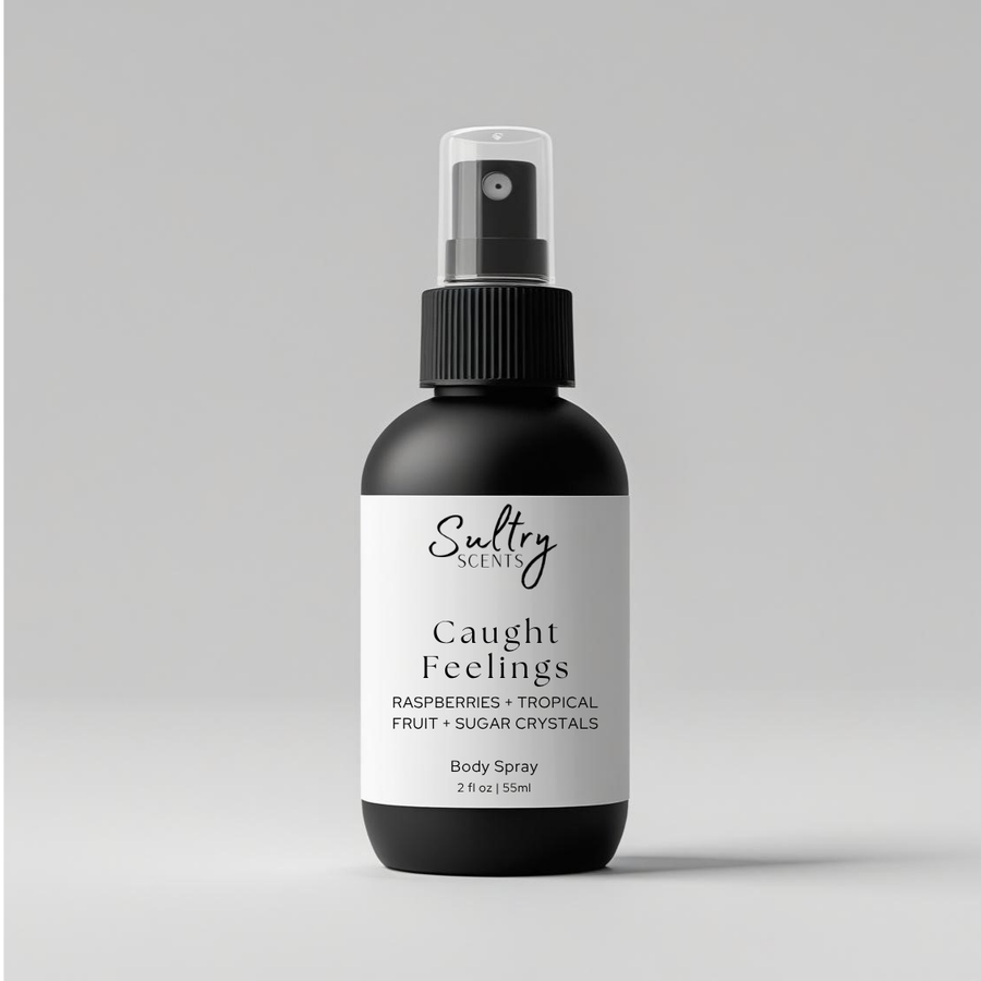 Sultry Scents Caught Feelings Body Spray with scent notes Raspberries and Tropical Fruit, in love with everything inspired perfume. Shows a 2 oz black bottle with white label.