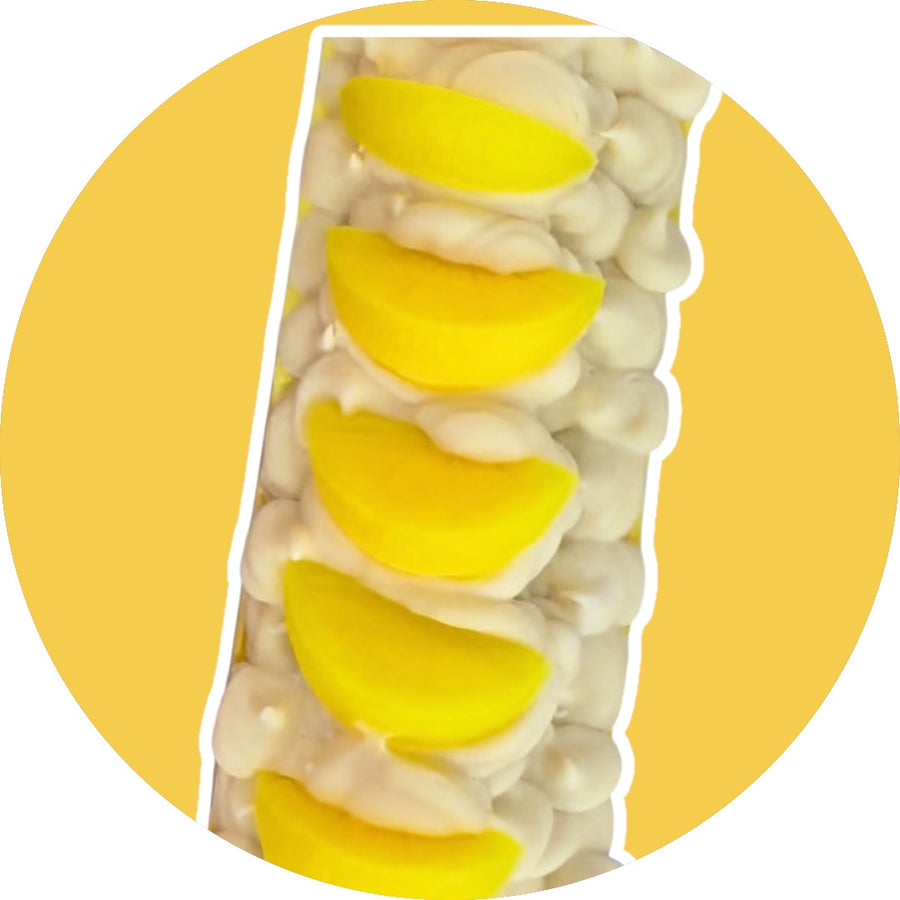Lemon scented soap bar with creamy white base and yellow lemon slices on top