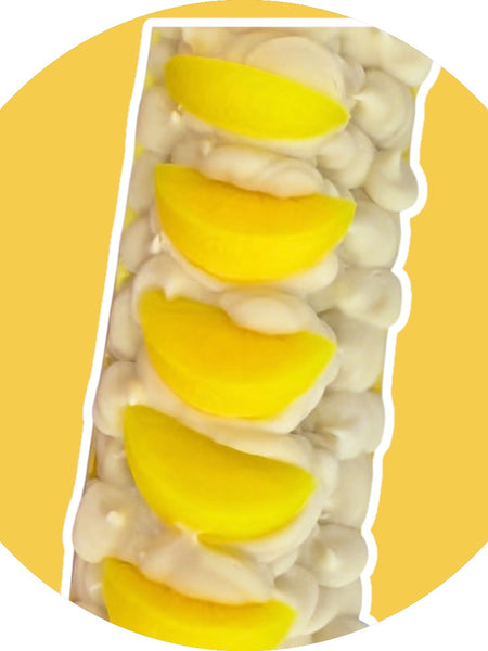 Lemon scented soap bar with creamy white base and yellow lemon slices on top