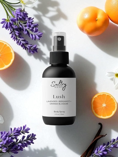 Sultry Scents Lush body spray surrounded by lavender, orange slices, and white flowers Libre perfume dupe Body spray