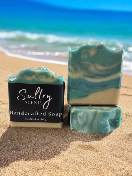 Sultry Scents luxury beach soap bar featuring a swirled design and ocean-inspired colors on sandy beach