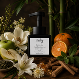 Sultry Scents Emerald Enchantment Luxury Foaming Hand Soap in a stylish black pump bottle surrounded with scent notes of bamboo, apple, mandarin, magnolia, amber, lily.