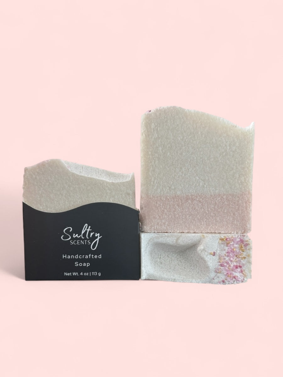 Sultry Scents luxury salt bar soap with white and blush layers and decorative pink salt crystals in black sleeve
