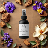 Sultry Scents Ghosted body spray bottle on wooden background with flowers and wood chips Mojave Ghost body spray dupe