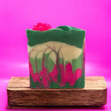 Pear Jam inspired handcrafted soap by Sultry Scents with green, cream, and pink swirls on wooden stand