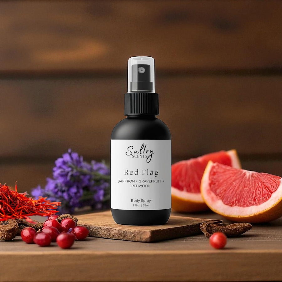 Sultry Scents Red Flag body spray bottle on wooden board with grapefruit saffron berries Polo Red inspired body spray