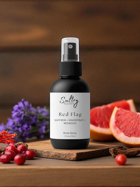 Sultry Scents Red Flag body spray bottle on wooden board with grapefruit saffron berries Polo Red inspired body spray