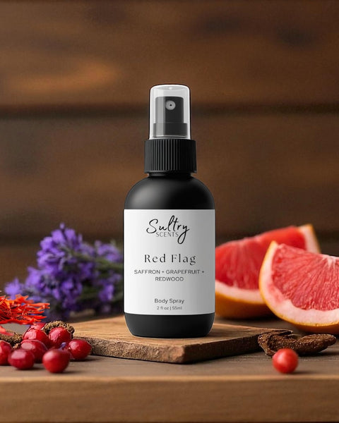 Sultry Scents Red Flag body spray bottle on wooden board with grapefruit saffron berries Polo Red inspired body spray