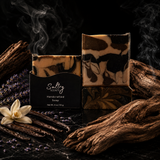 Smoky Vanilla Woods soap bar in a stylish presentation with dark swirls and aromatic elements