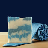 Sultry Scents artisanal marbled bar on wooden board next to blue tie Soap inspired by Polo Sport with grit.