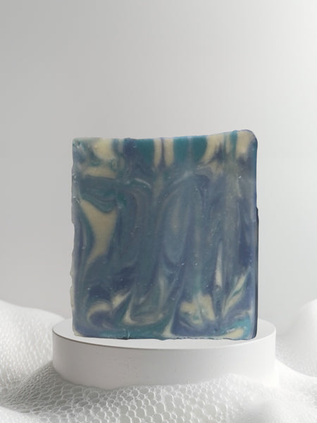 Sultry Scents Wood Sage & Sea Salt inspired soap with blue and cream marbled design on white pedestal
