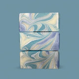 Sultry Scents Wood Sage & Sea Salt inspired soap bars with blue and white swirled design stacked on blue background