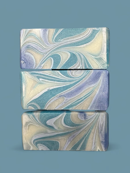 Sultry Scents Wood Sage & Sea Salt inspired soap bars with blue and white swirled design stacked on blue background
