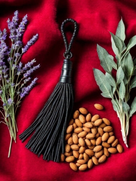 Tom Ford Fucking Fabulous dupe ingredients with lavender, almond nuts, sage leaves, and black tassel on red fabric