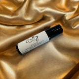 Sultry Scents Vetiver suede roll on perfume bottle on golden satin fabric background